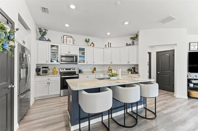 a kitchen with stainless steel appliances a refrigerator stove microwave and cabinets