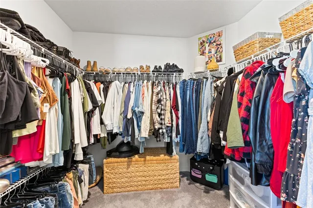 a view of walk in closet with clothes