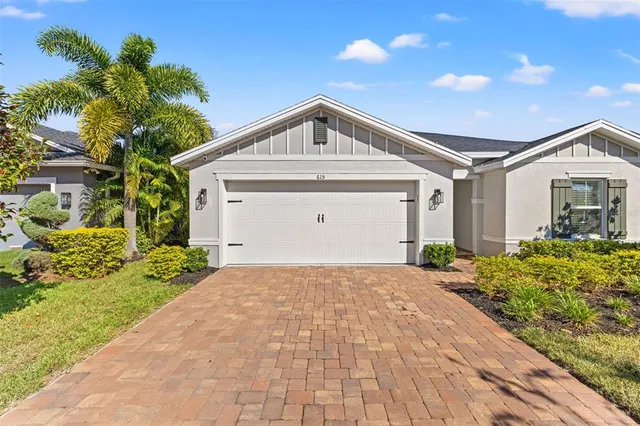 a view of a house with a yard and potted plants