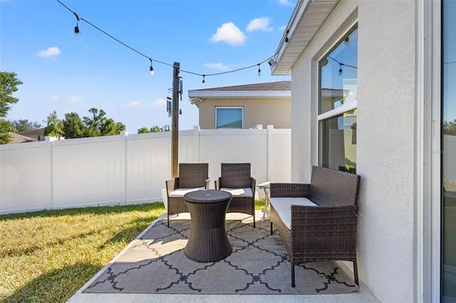 a view of a patio with table and chairs and potted plants