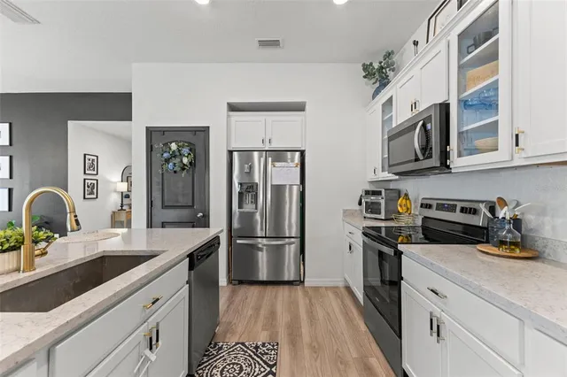 a kitchen with stainless steel appliances granite countertop a refrigerator and a sink