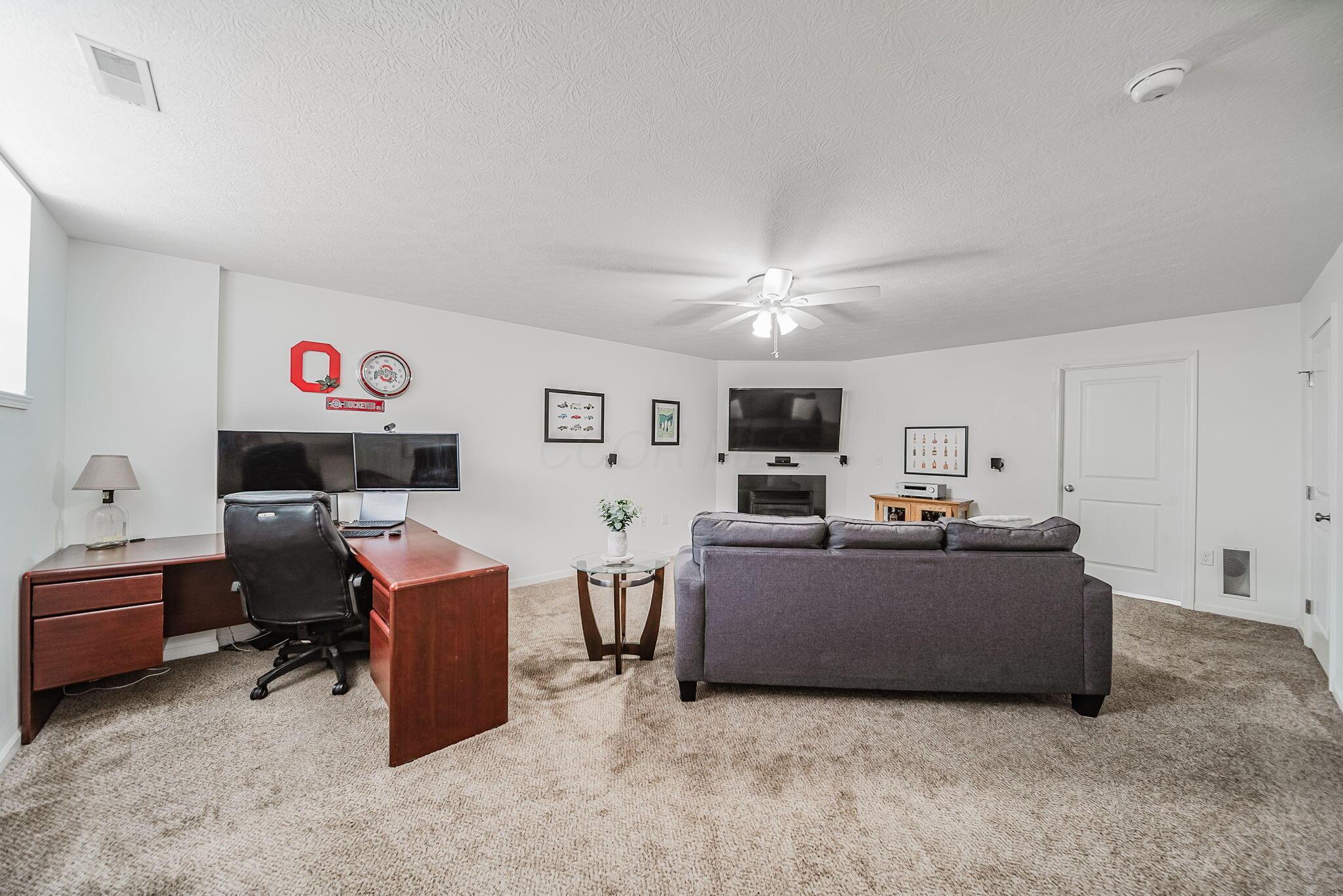 6186 Needletail Road, Unit 66 Columbus, OH 43230 - Photo 24 of 48 Finished lower level with daylight window, neutral decor, overhead lighting, and a cozy gas fireplace make this a beautiful area to spend quality time in for work and play!