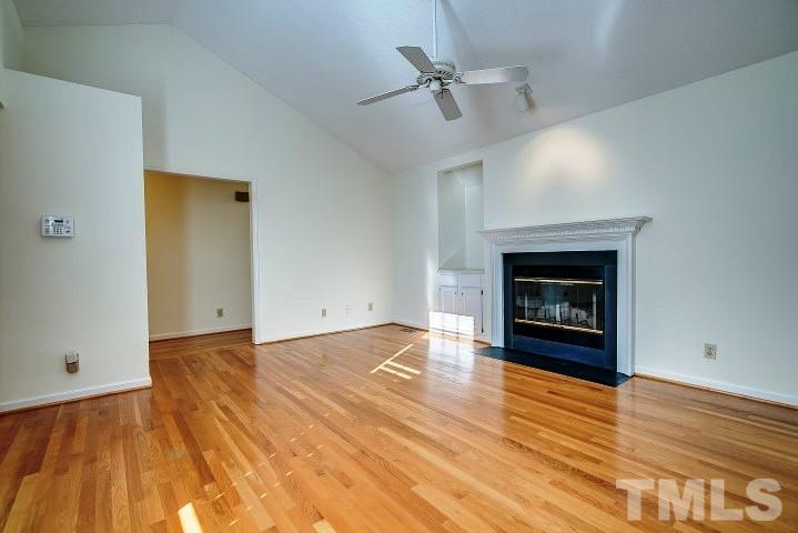 3913 Olde Coach Road Durham, NC 27707 - Photo 3 of 17 an empty room with wooden floor a fireplace