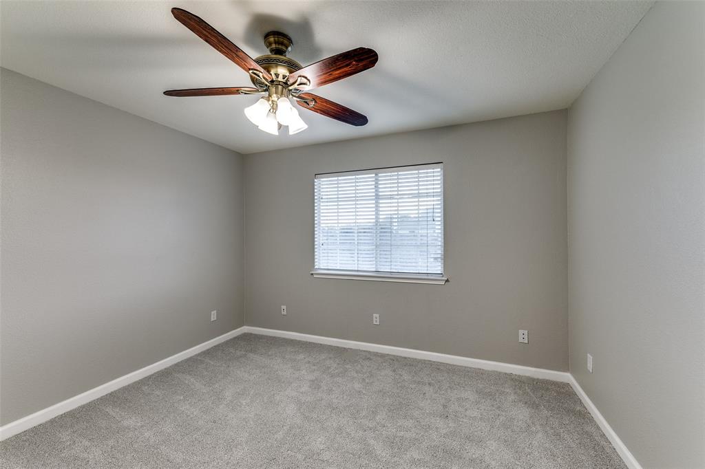 4532 Crown Ridge Drive Plano, TX 75024 - Photo 17 of 25 Neutral tone painted walls, textured ceiling, and gray carpeting