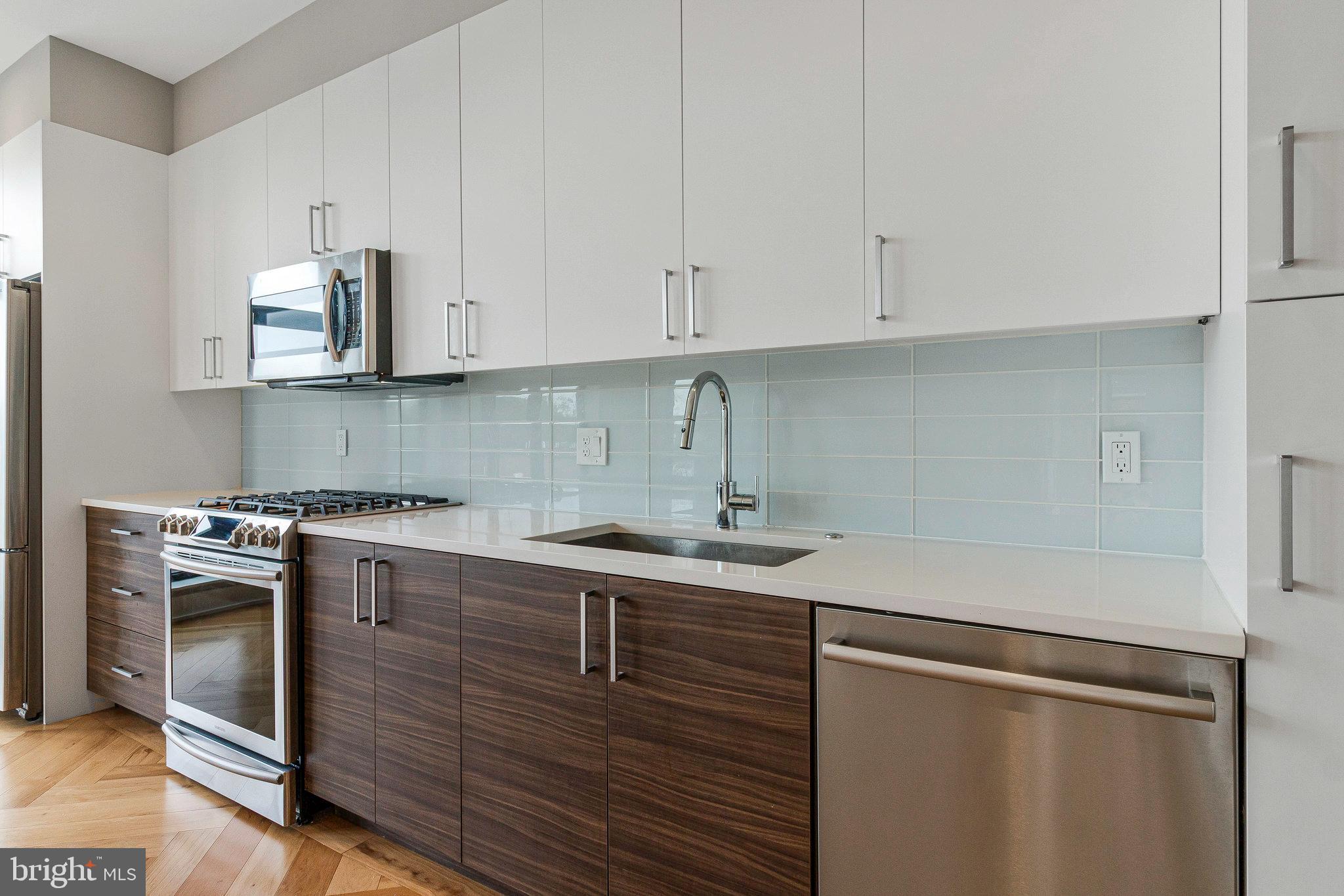 1345 K Street Southeast, Unit 406 Washington, DC 20003 - Photo 27 of 46 a kitchen with stainless steel appliances granite countertop a sink stove and cabinets