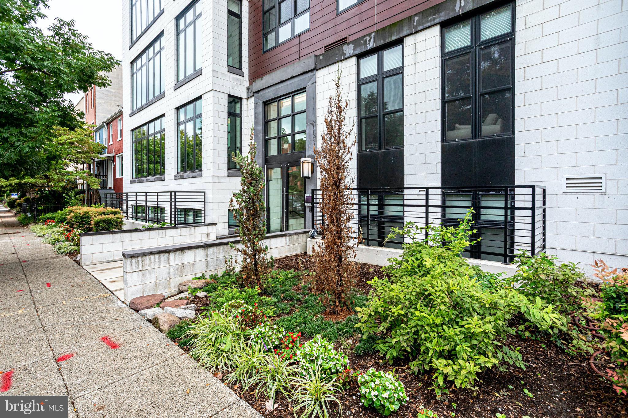 1345 K Street Southeast, Unit 406 Washington, DC 20003 - Photo 40 of 46 a view of a house with brick walls and a small yard