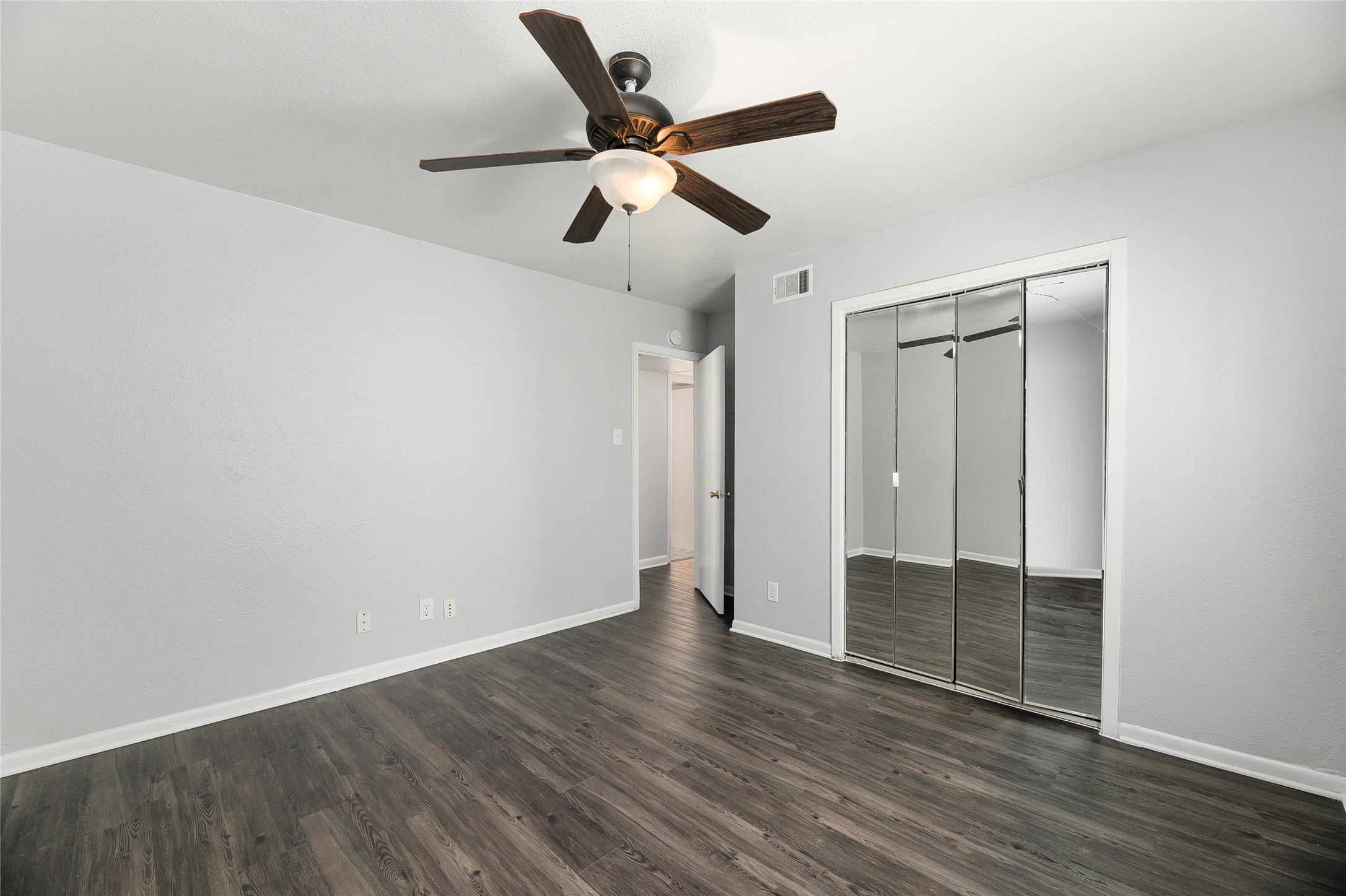 2408 Longview Street, Unit 113 Austin, TX 78705 - Photo 18 of 23 Unfurnished bedroom featuring dark wood finished floors, a closet, and a ceiling fan