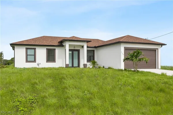 a front view of house with yard and green space