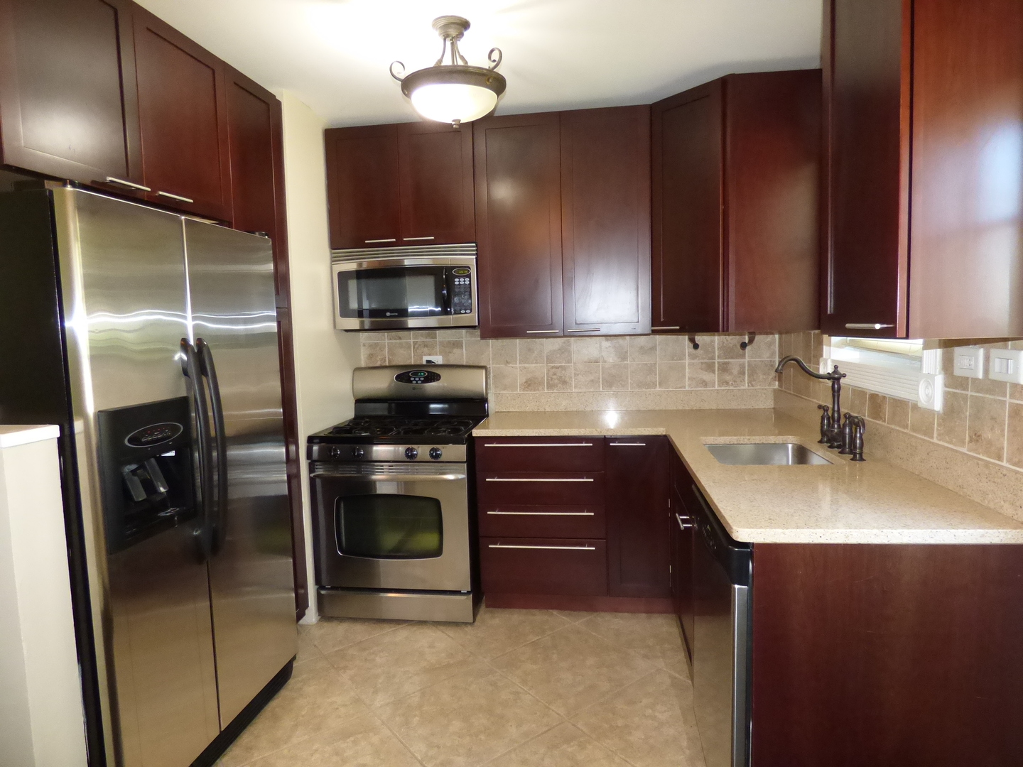 5416 Conrad Street Skokie, IL 60077 - Photo 3 of 14 a kitchen with a sink stainless steel appliances and cabinets