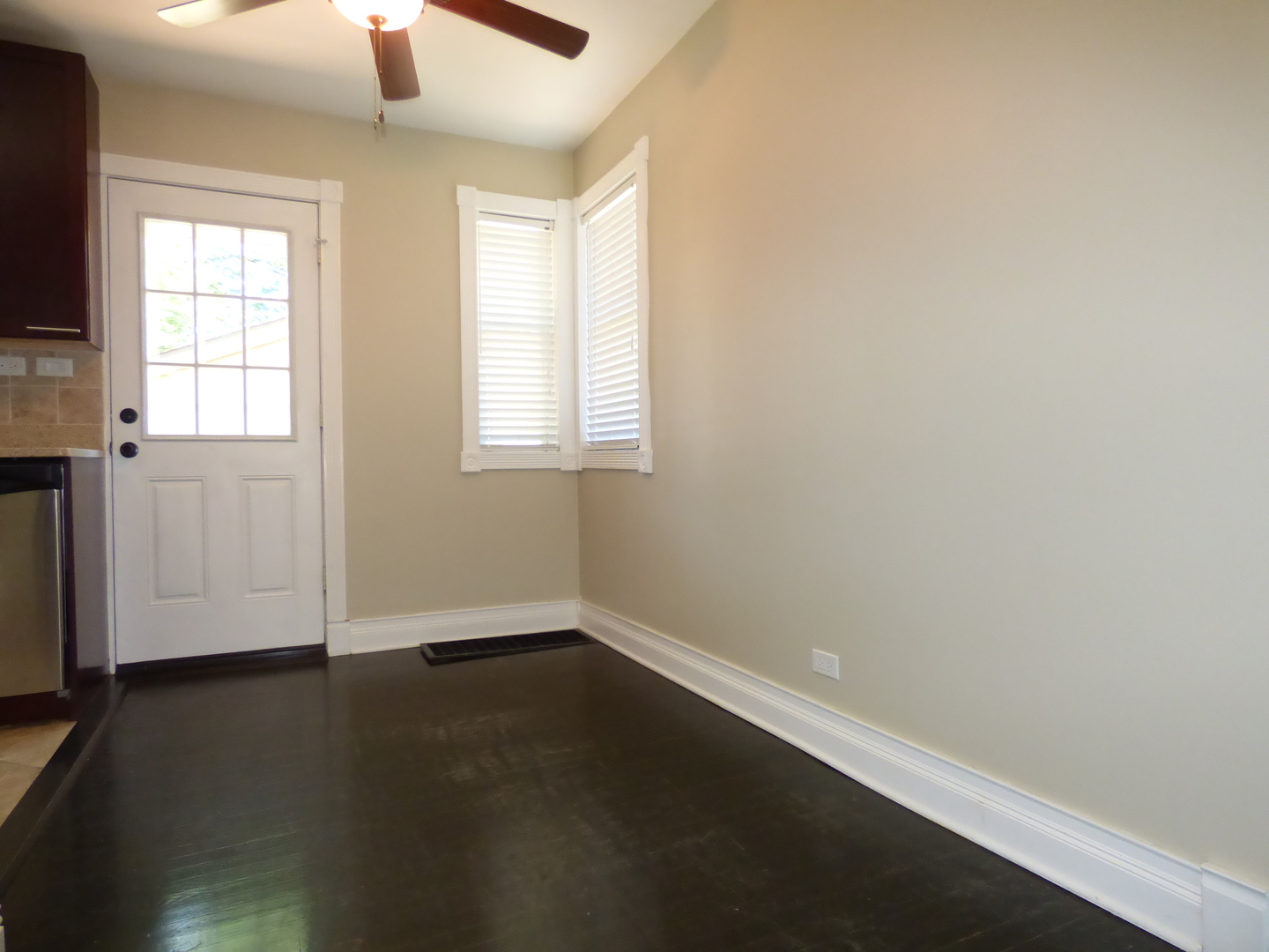 5416 Conrad Street Skokie, IL 60077 - Photo 4 of 14 an empty room with wooden floor fan and windows
