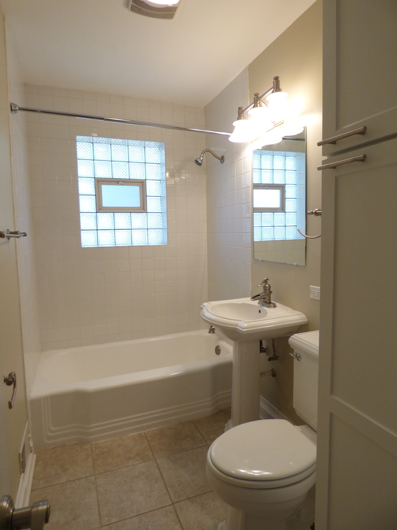 5416 Conrad Street Skokie, IL 60077 - Photo 7 of 14 a bathroom with a sink a toilet and shower