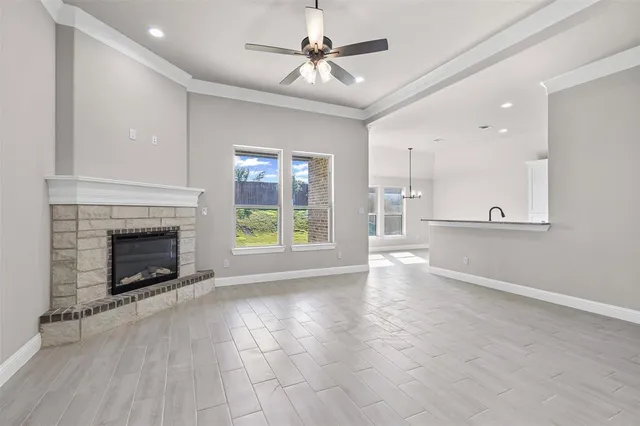an empty room with windows fireplace and fans