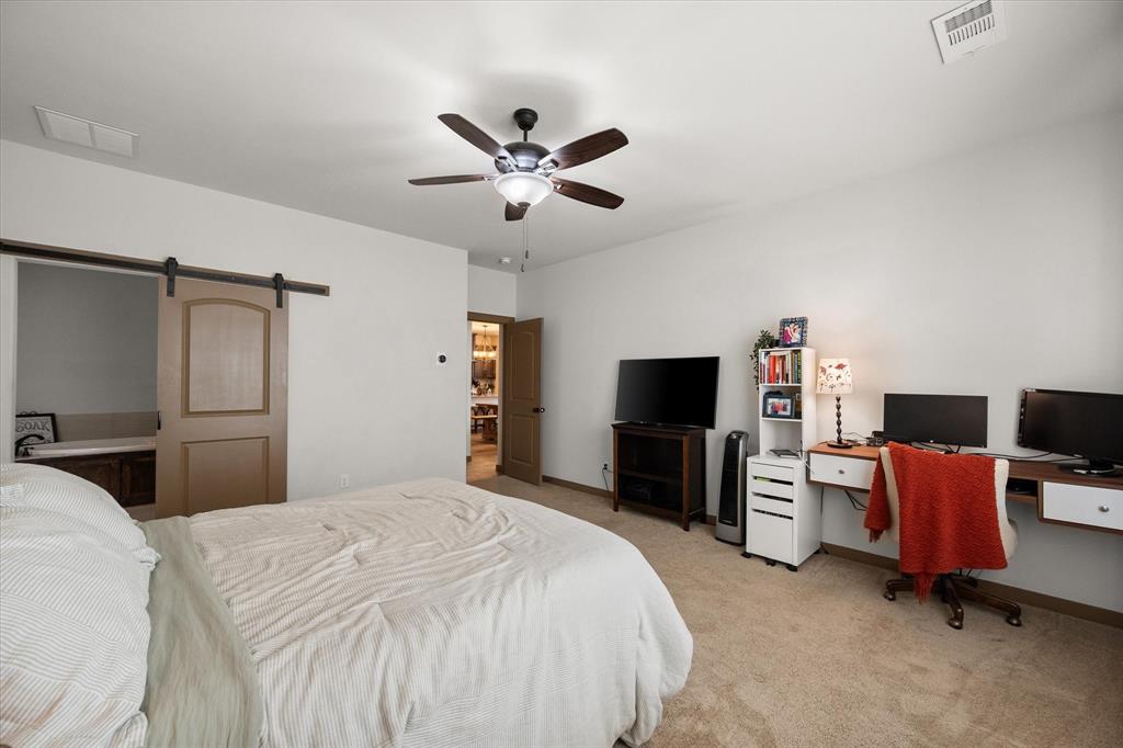 707 Phillips Court Mansfield, TX 76063 - Photo 14 of 28 a bedroom with a bed and a flat screen tv