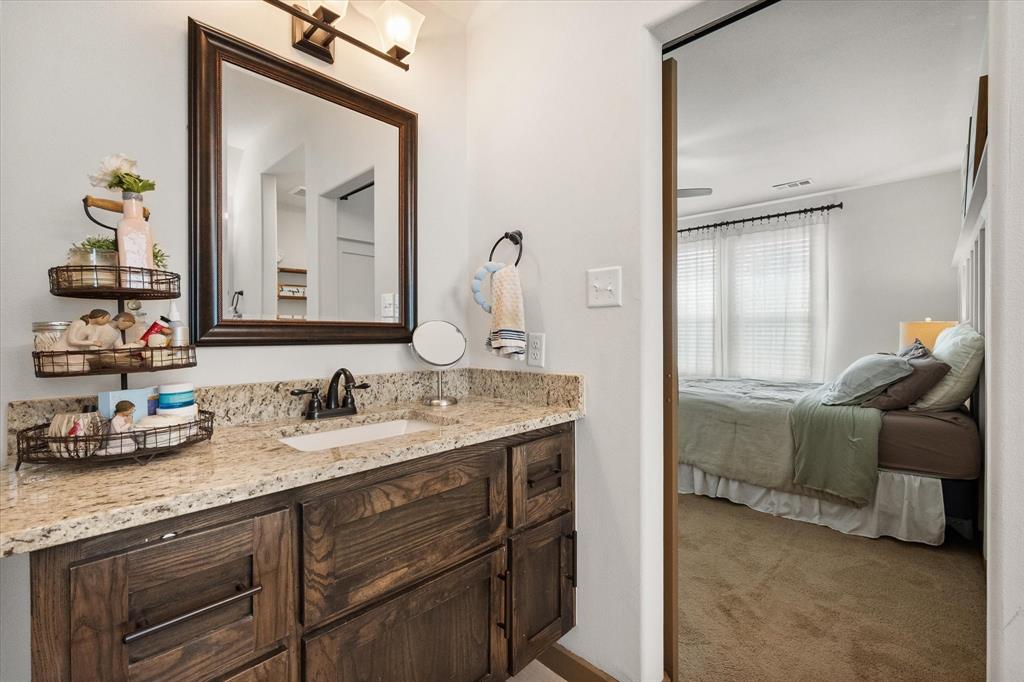 707 Phillips Court Mansfield, TX 76063 - Photo 15 of 28 a en suite bathroom with a granite countertop sink and a mirror