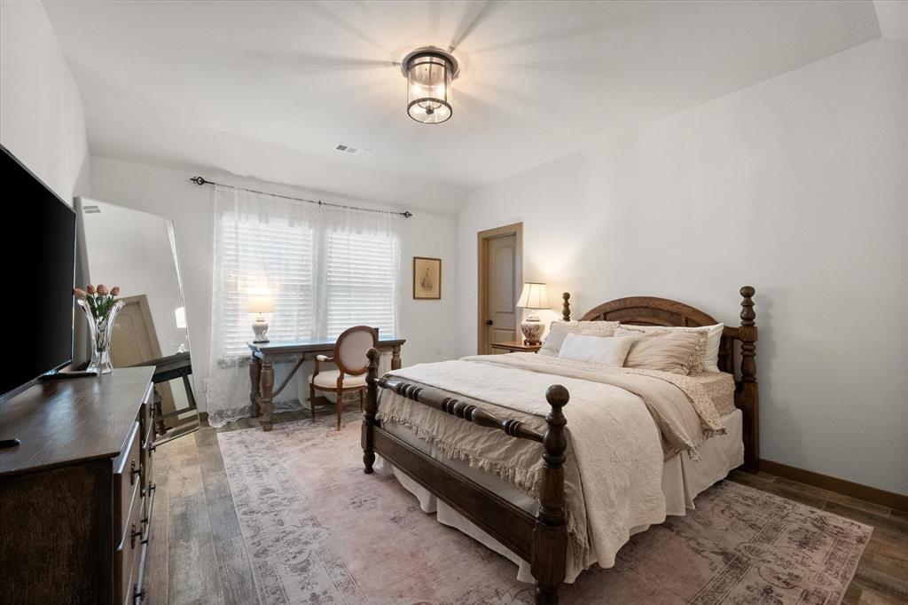 707 Phillips Court Mansfield, TX 76063 - Photo 16 of 28 a bedroom with bed a chair and a chandelier