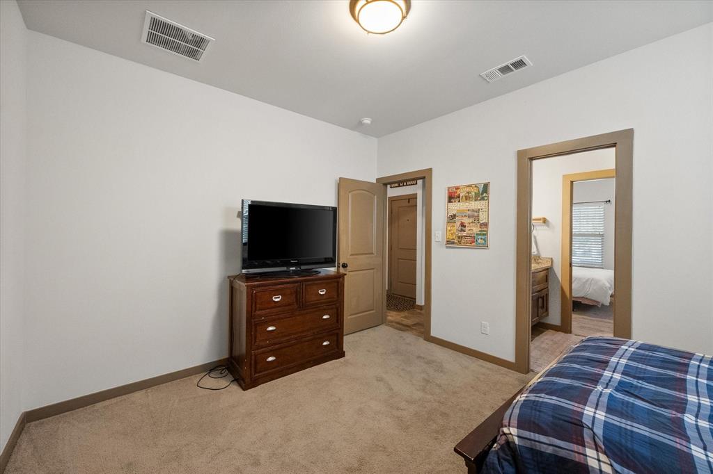 707 Phillips Court Mansfield, TX 76063 - Photo 18 of 28 a bedroom with a bed and a flat tv screen on wall