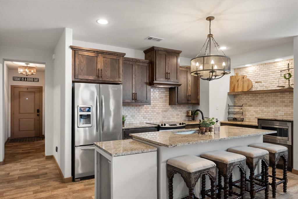 707 Phillips Court Mansfield, TX 76063 - Photo 2 of 28 a kitchen with stainless steel appliances kitchen island a refrigerator and a stove