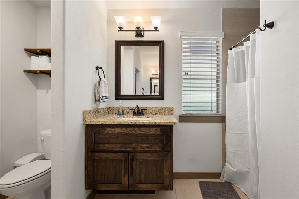 707 Phillips Court Mansfield, TX 76063 - Photo 26 of 28 a bathroom with a toilet sink and mirror