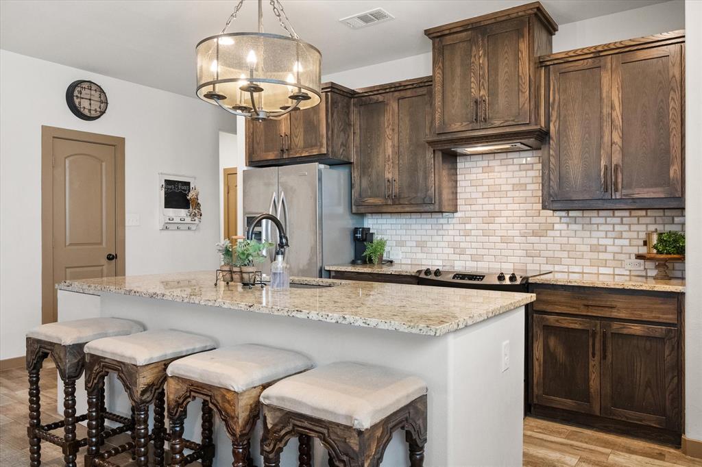 707 Phillips Court Mansfield, TX 76063 - Photo 5 of 28 a kitchen with stainless steel appliances granite countertop a sink and a refrigerator