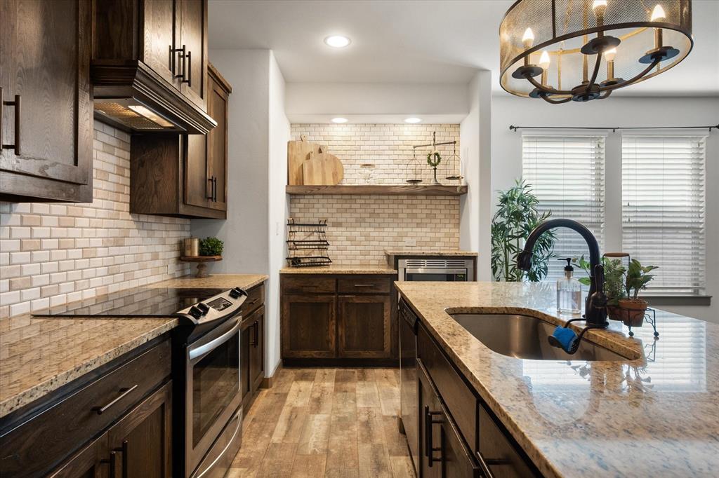 707 Phillips Court Mansfield, TX 76063 - Photo 6 of 28 a kitchen with stainless steel appliances granite countertop a sink a stove and a wooden floors