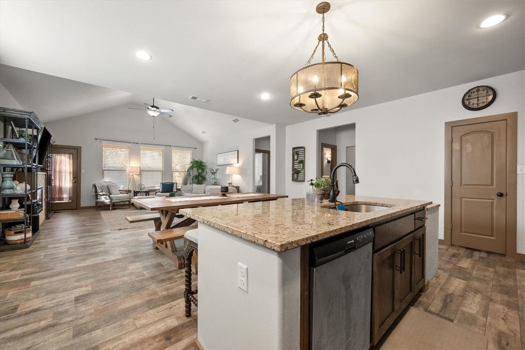 707 Phillips Court Mansfield, TX 76063 - Photo 7 of 28 a kitchen with a stove a counter space a sink and living room view