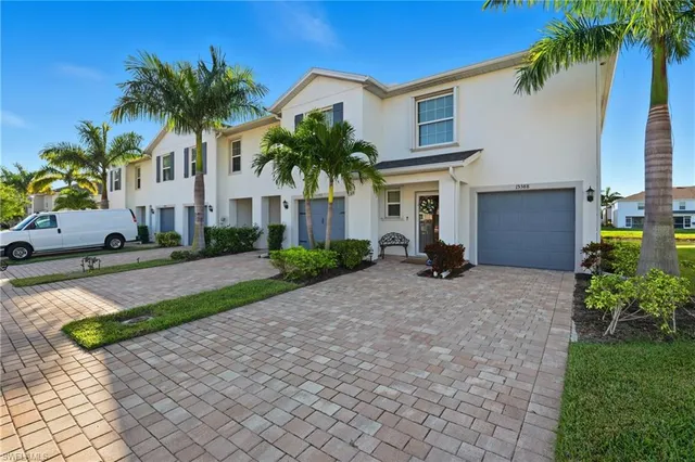a view of a house with a yard and palm trees