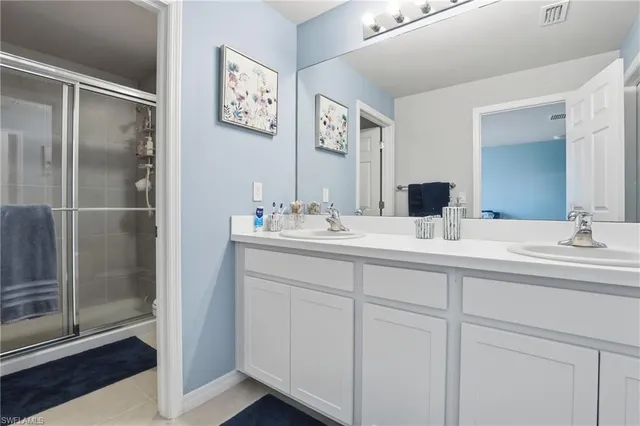 a bathroom with double sink and a mirror