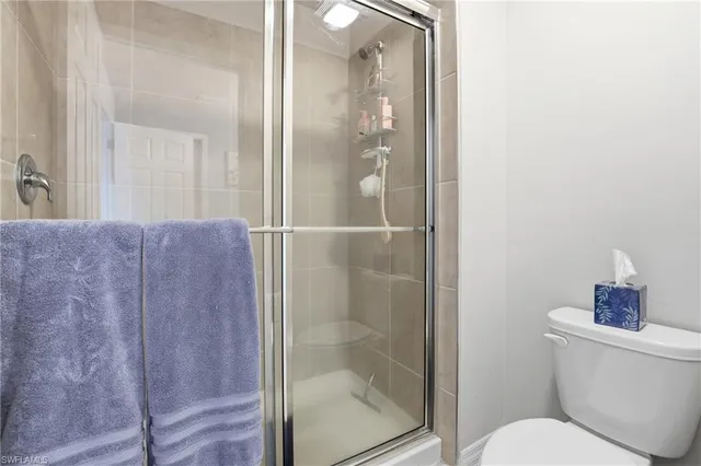 a bathroom with a toilet and a glass shower door