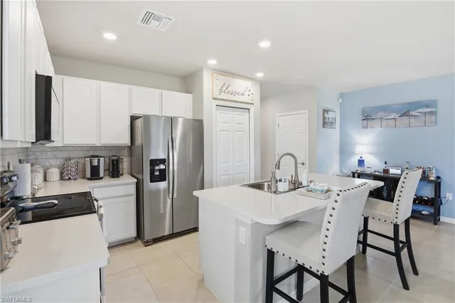 a kitchen with stainless steel appliances granite countertop a table and chairs