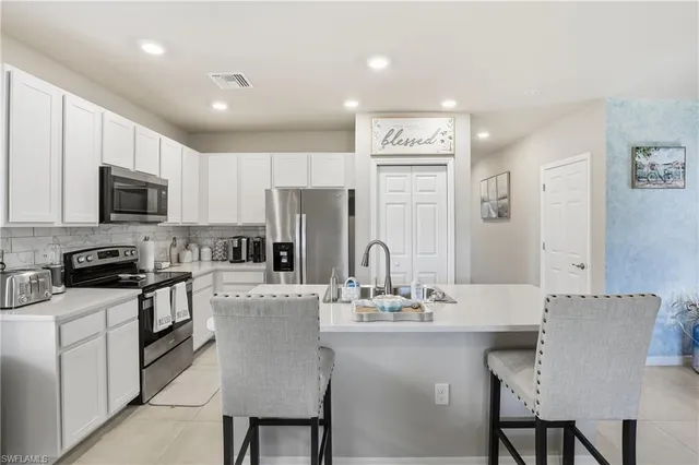 a kitchen with stainless steel appliances granite countertop a stove a sink a microwave a dining table and chairs