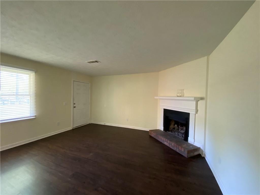 1981 Patterson Circle Lawrenceville, GA 30044 - Photo 18 of 19 an empty room with wooden floor fireplace and windows