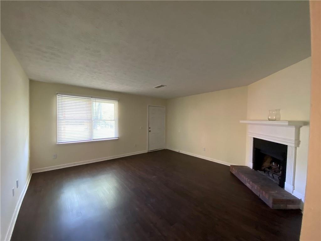 1981 Patterson Circle Lawrenceville, GA 30044 - Photo 7 of 19 an empty room with wooden floor fireplace and windows
