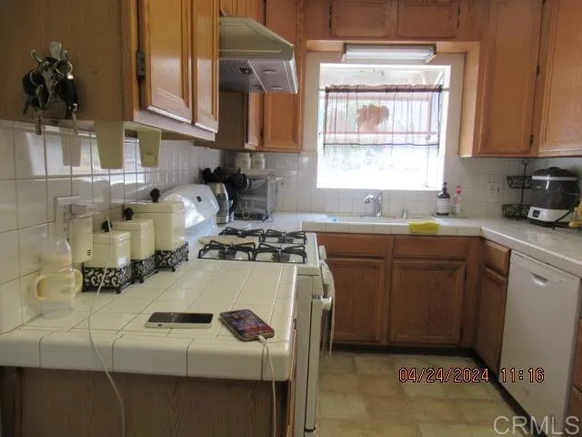 a kitchen with a sink a stove and cabinets