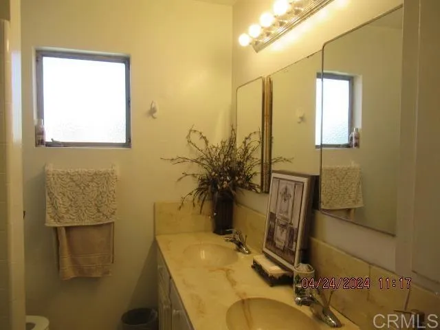 a bathroom with a sink a toilet and mirror