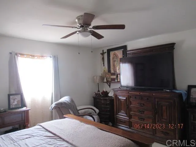 a bedroom with a bed and a flat tv screen on the dresser