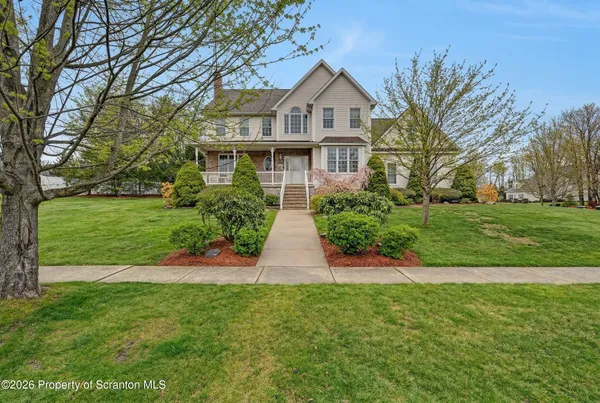 a view of a house with a big yard and potted plants