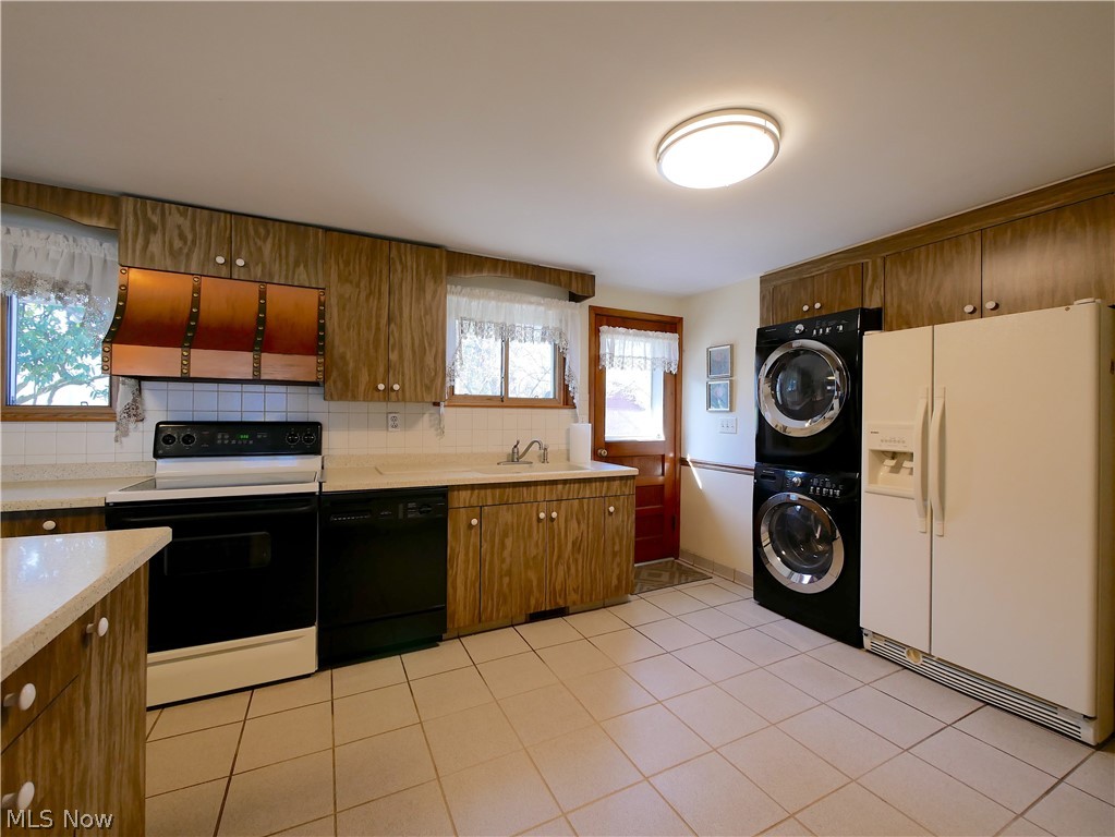 57500 Hospital Road Bellaire, OH 43906 - Photo 22 of 22 Kitchen with stacked washer / drying machine, backsplash, light tile floors, and white appliances