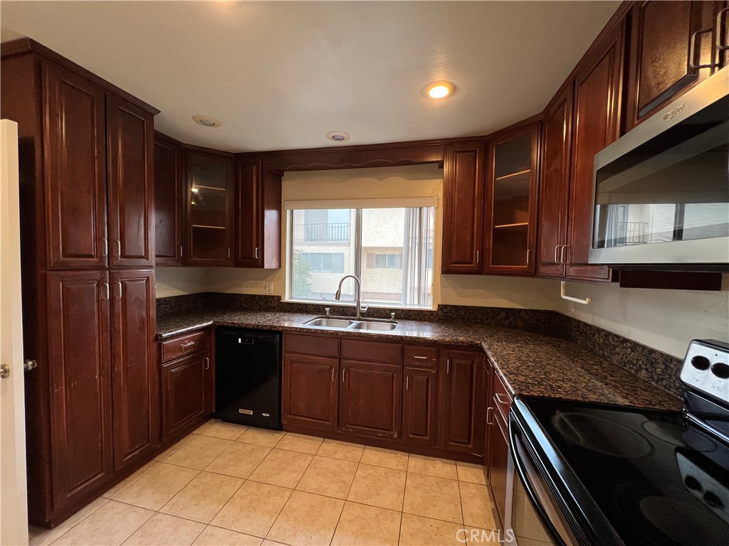 28129 Ridgethorne Court, Unit 34 Rancho Palos Verdes, CA 90275 - Photo 24 of 27 a kitchen with stainless steel appliances granite countertop wooden cabinets a stove top oven a sink and dishwasher