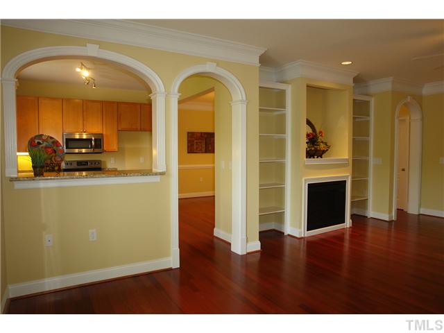 3811 Lunceston Way, Unit 203 Raleigh, NC 27613 - Photo 7 of 20 a view of empty room with fireplace and wooden floor