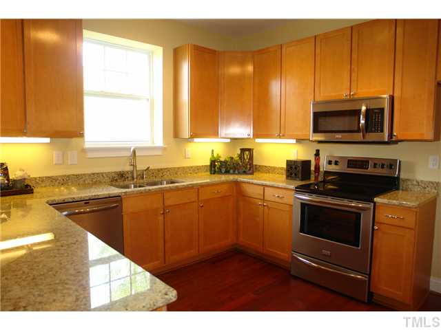 3811 Lunceston Way, Unit 203 Raleigh, NC 27613 - Photo 9 of 20 a kitchen with stainless steel appliances granite countertop a stove a sink and a microwave