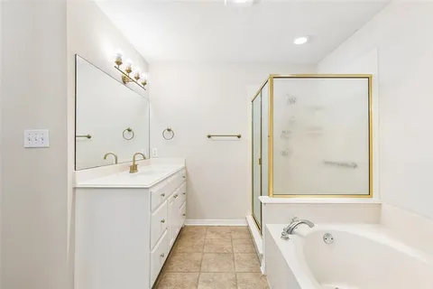 a bathroom with a tub sink and mirror