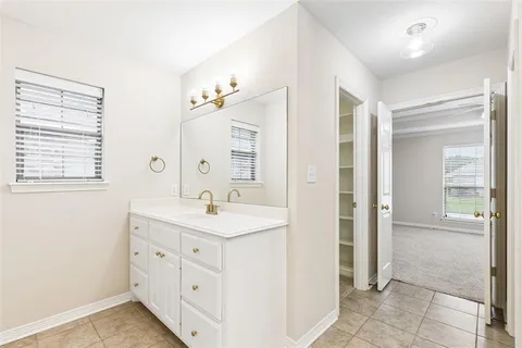 a spacious bathroom with a shower a sink and a mirror