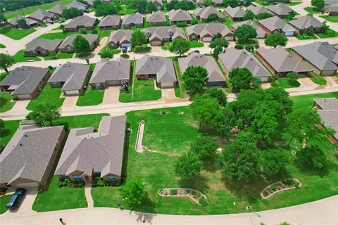 an aerial view of residential houses with outdoor space and street view