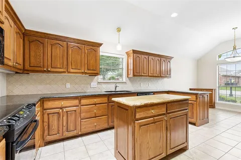 a utility room with stainless steel appliances granite countertop a sink stove and cabinets