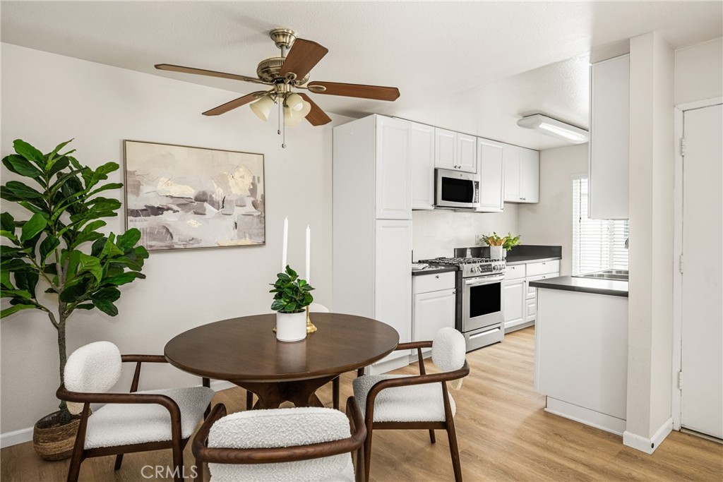 1420 E Cabrillo Park Drive, Unit E Santa Ana, CA 92701 - Photo 23 of 46 a kitchen with stainless steel appliances a white table and chairs in it