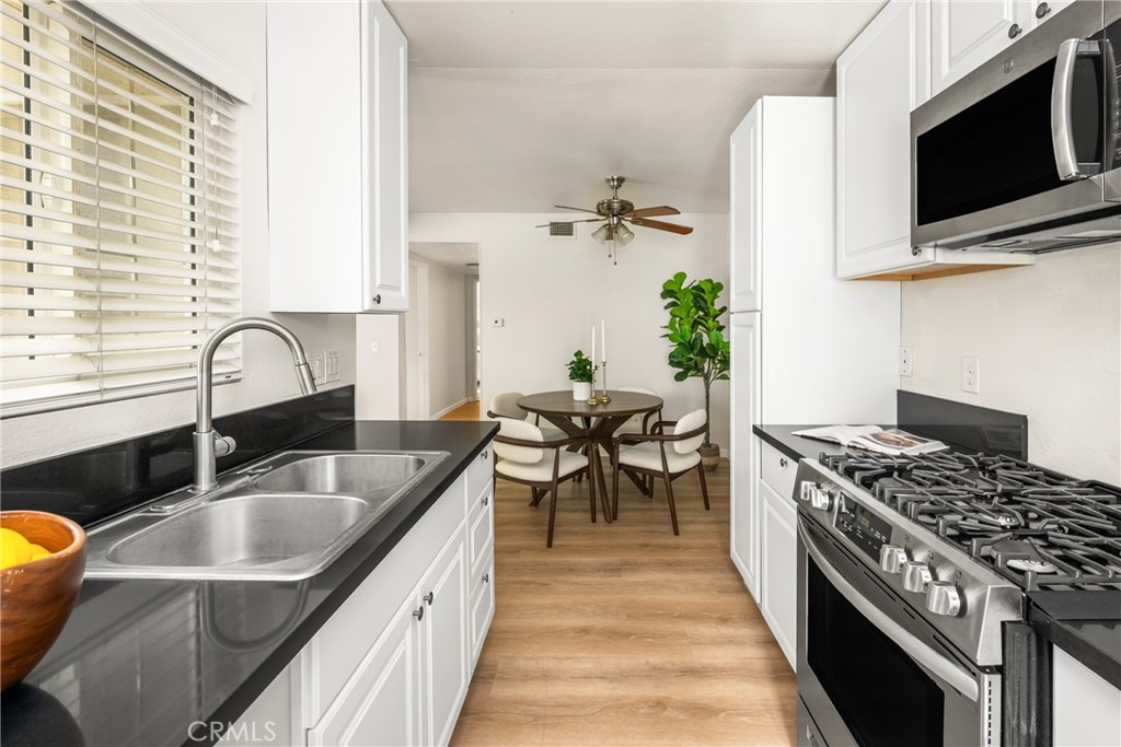 1420 E Cabrillo Park Drive, Unit E Santa Ana, CA 92701 - Photo 26 of 46 a kitchen with stainless steel appliances a sink stove and microwave