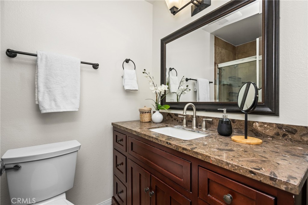 1420 E Cabrillo Park Drive, Unit E Santa Ana, CA 92701 - Photo 32 of 46 a bathroom with a granite countertop sink and a toilet