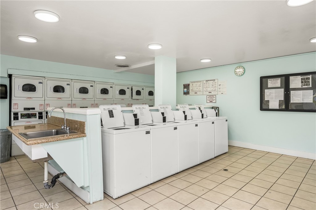 1420 E Cabrillo Park Drive, Unit E Santa Ana, CA 92701 - Photo 40 of 46 a large white kitchen with a white countertops a stove a dining table and chairs