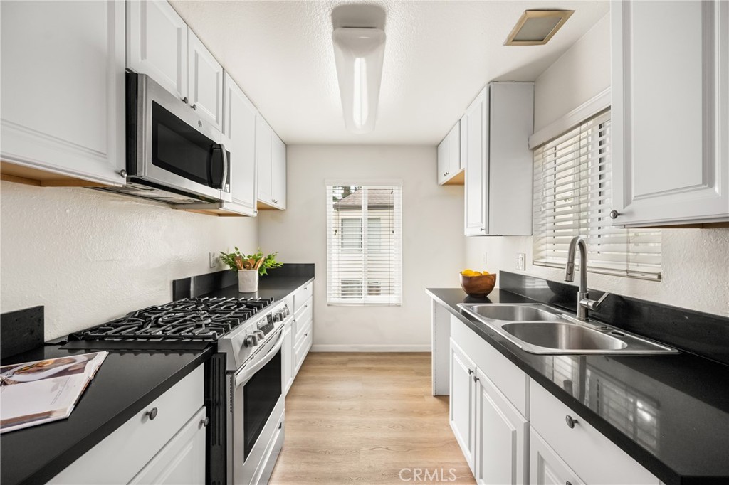 1420 E Cabrillo Park Drive, Unit E Santa Ana, CA 92701 - Photo 5 of 46 a kitchen with stainless steel appliances granite countertop a sink and a stove