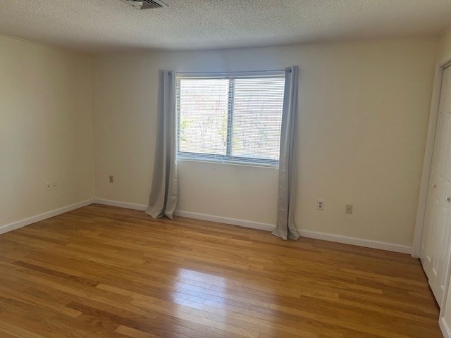 181 Littleton Road, Unit 236 Chelmsford, MA 01824 - Photo 4 of 14 an empty room with wooden floor and windows